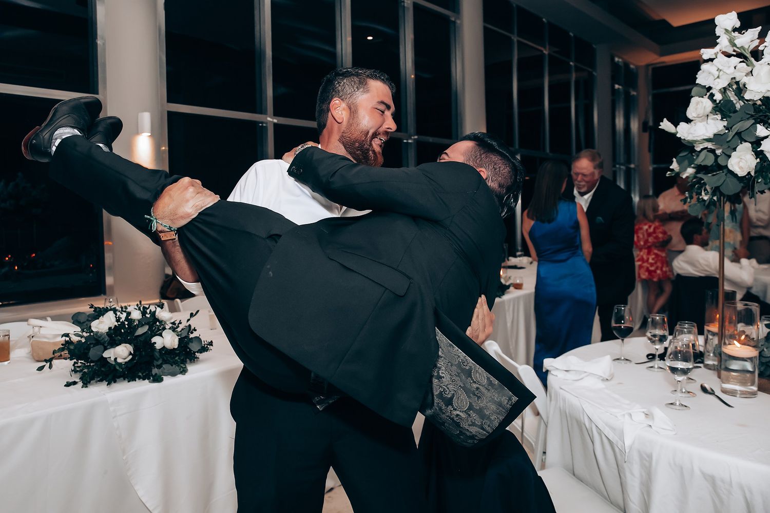 Wedding reception party with guests dancing and celebrating on dance floor.