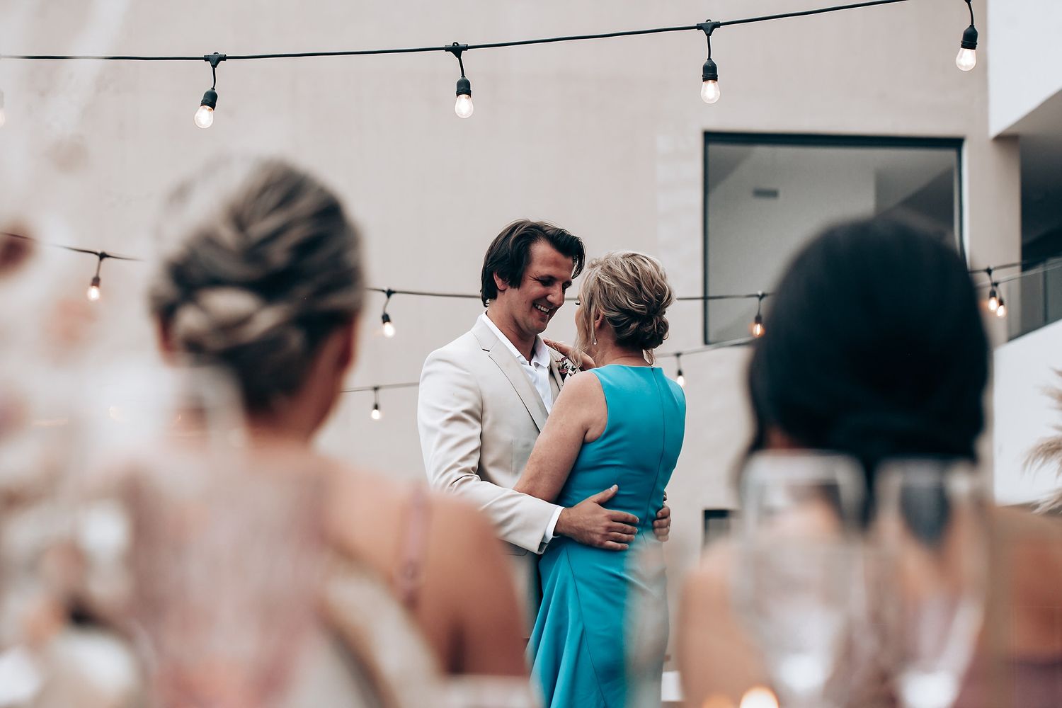 String lights and elegant decor create romantic ambiance at indoor wedding reception.