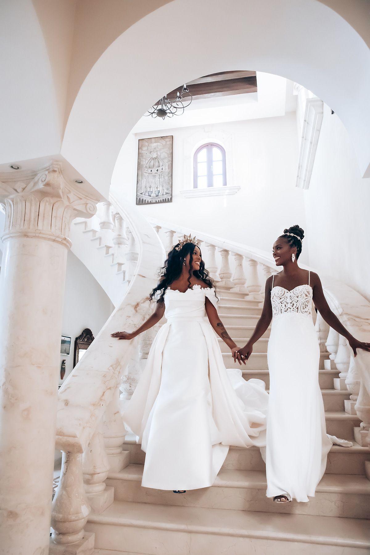 Wedding party in white dresses dances and celebrates in an elegant white interior space.
