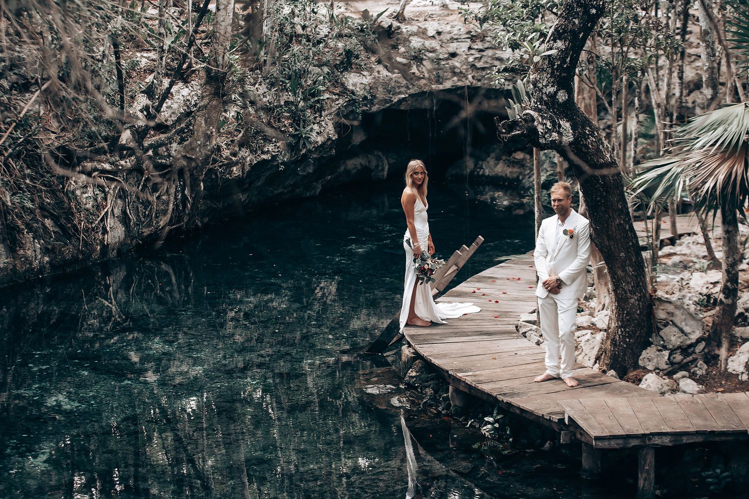 Intimate cave wedding ceremony with wooden walkways and natural rock formations.