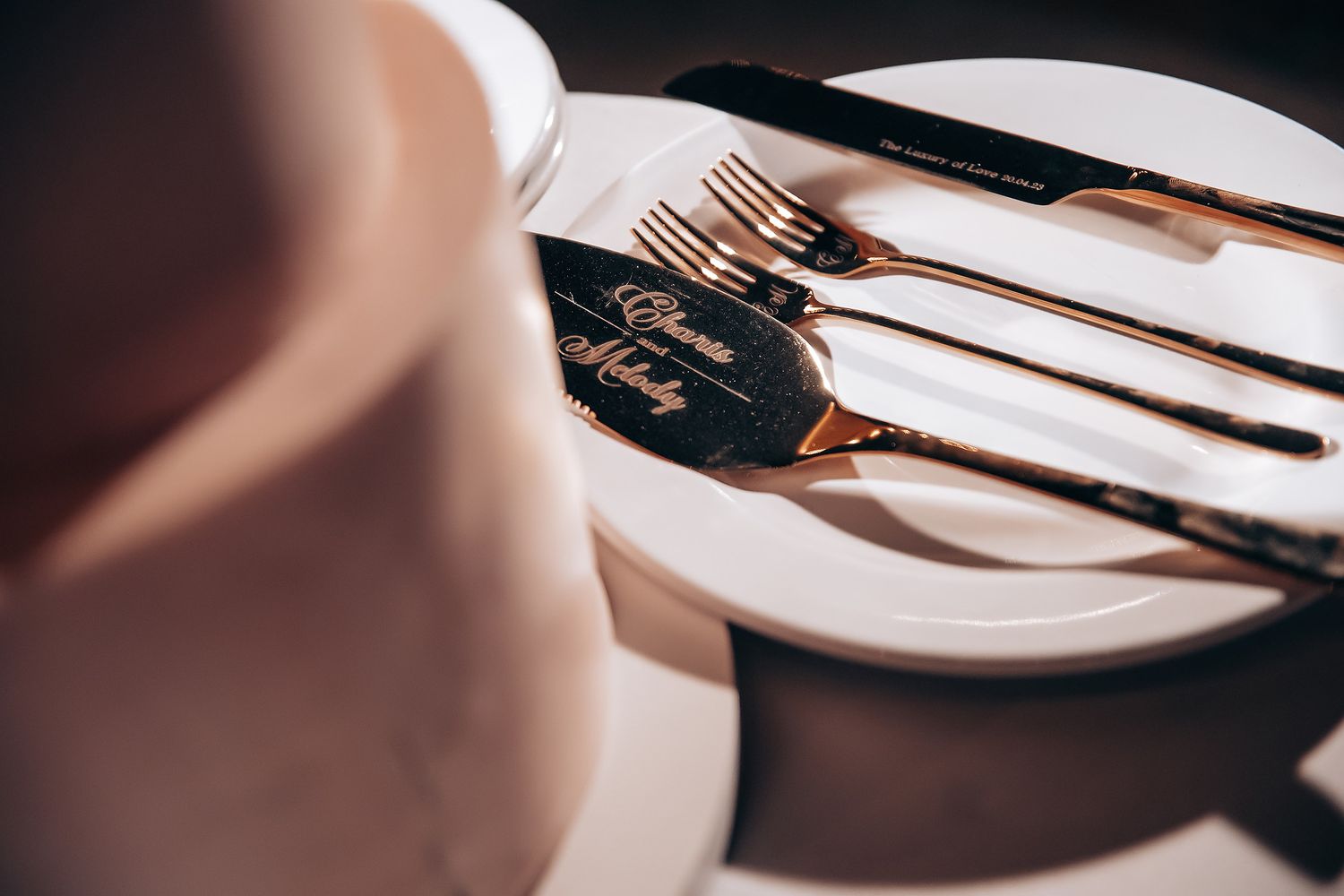 Elegant place setting with silverware and plates at a wedding reception.