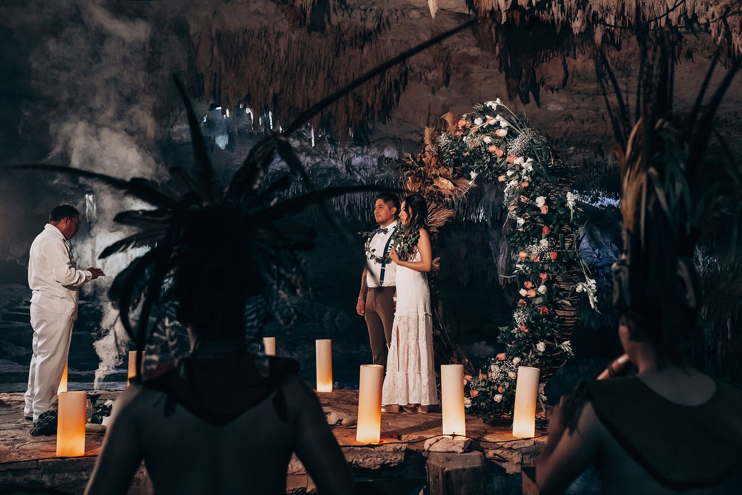 Wedding guests dancing and celebrating on an outdoor dance floor illuminated by warm lighting.