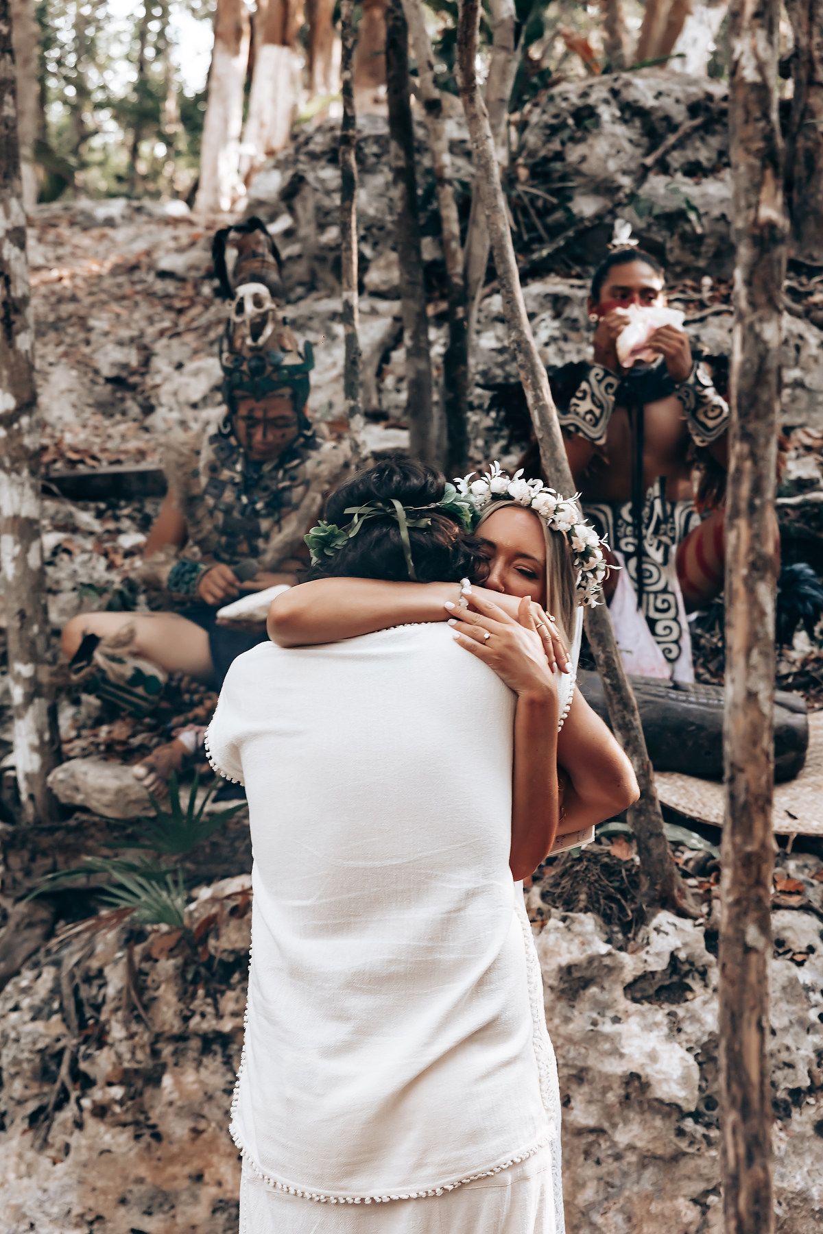 A series of candid moments showing two people in white attire embracing in a wooded outdoor setting.
