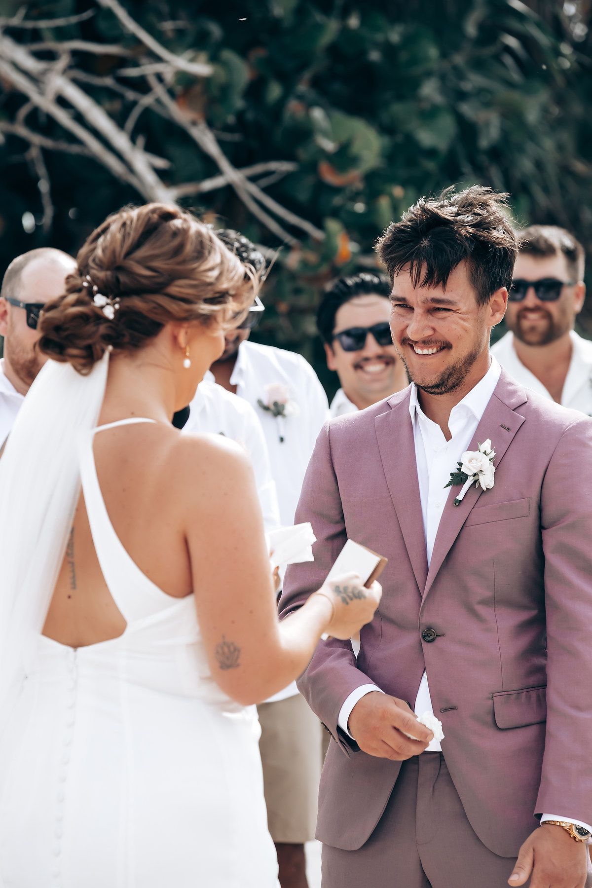 Couple shares joyful first look moment during beach wedding ceremony.