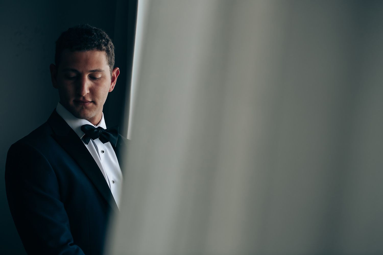 Elegant couple sharing intimate moments during formal wedding photoshoot in black and white.