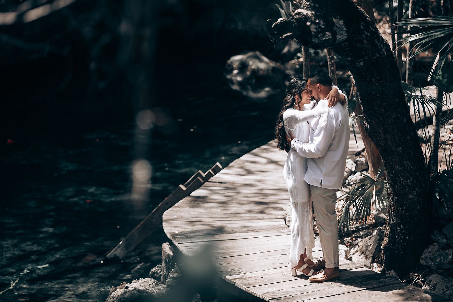 Intimate forest wedding ceremony with attendees gathered in a shaded woodland setting.