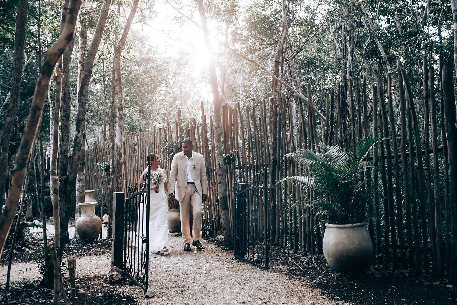 Sunlit forest path decorated for an outdoor wedding ceremony.