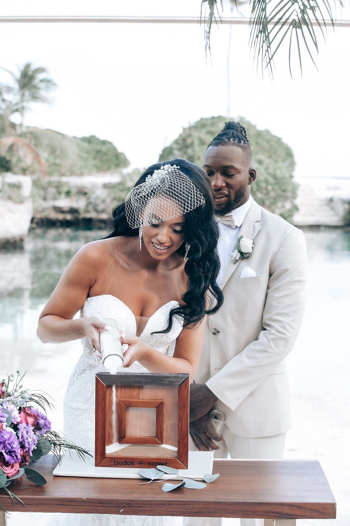 Newlyweds sharing a joyful moment while signing their marriage certificate at an outdoor ceremony.