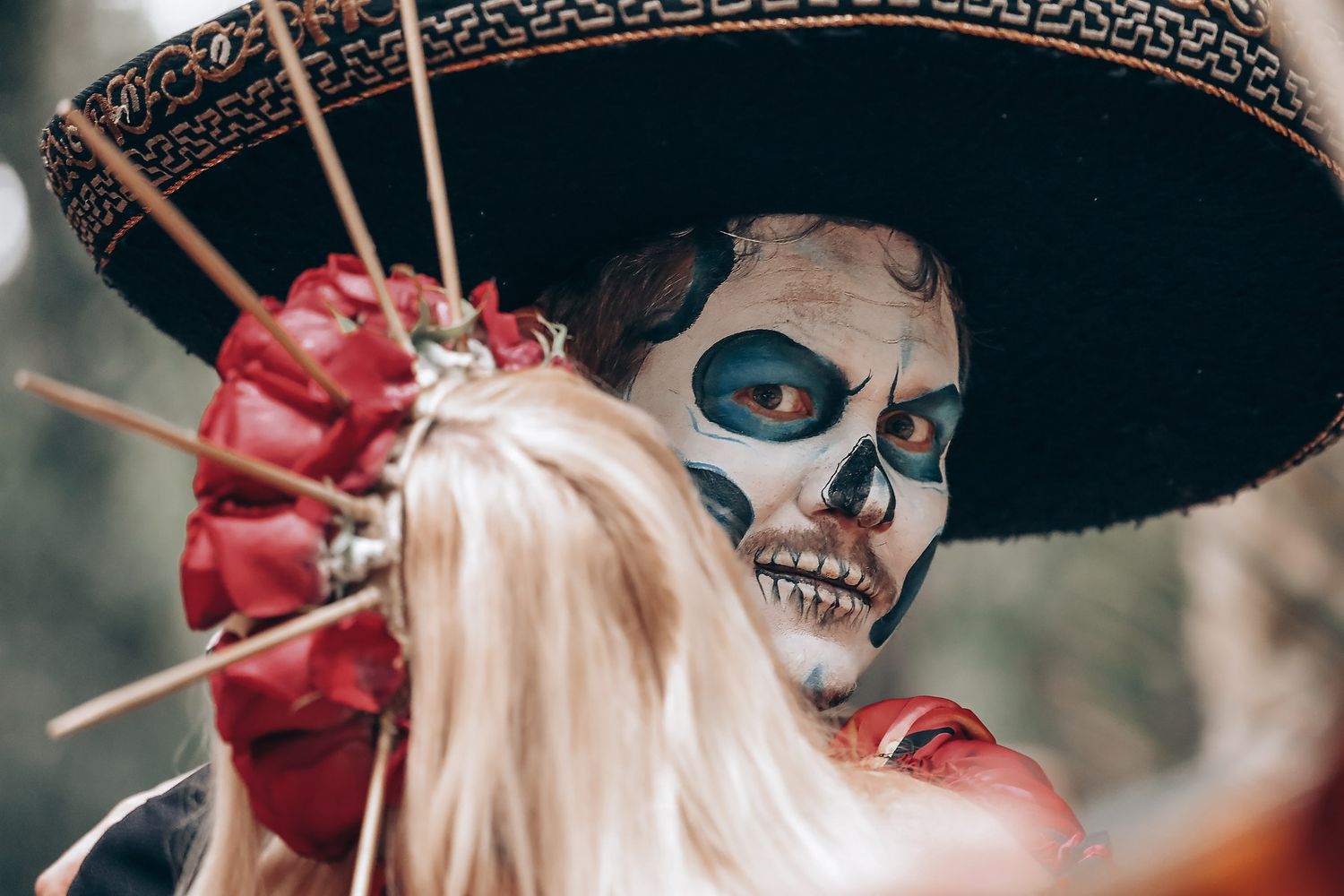 Close-up shot of elaborate Day of the Dead makeup and traditional Mexican sombrero details.