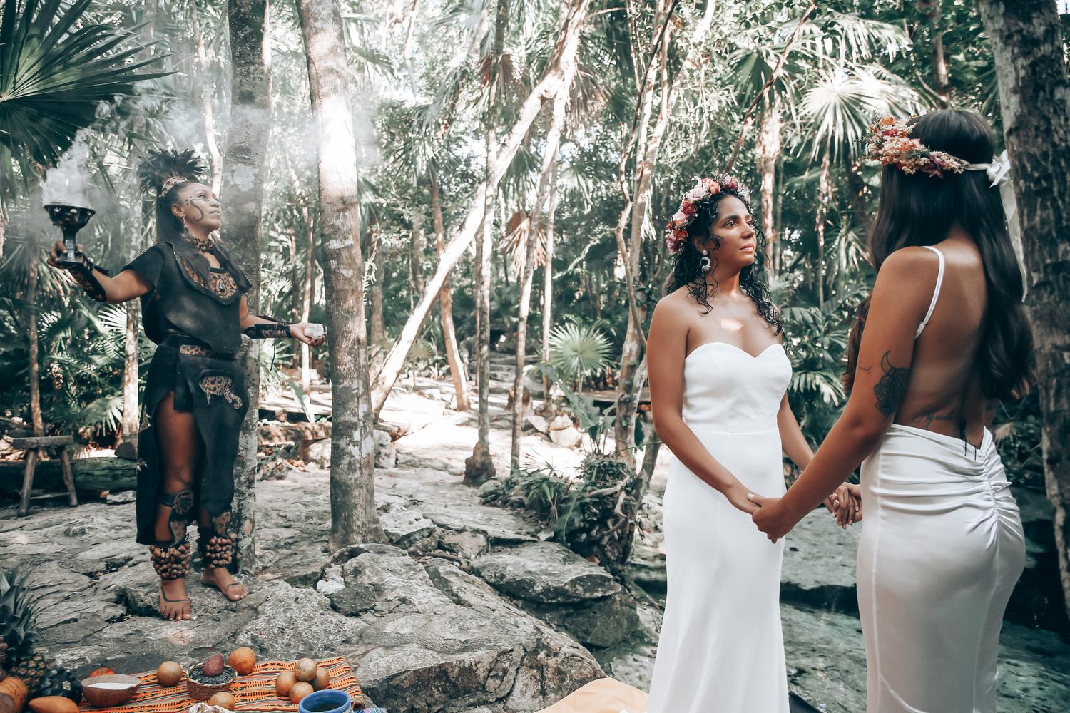 Intimate outdoor ceremony in a tropical forest setting with traditional cultural elements.
