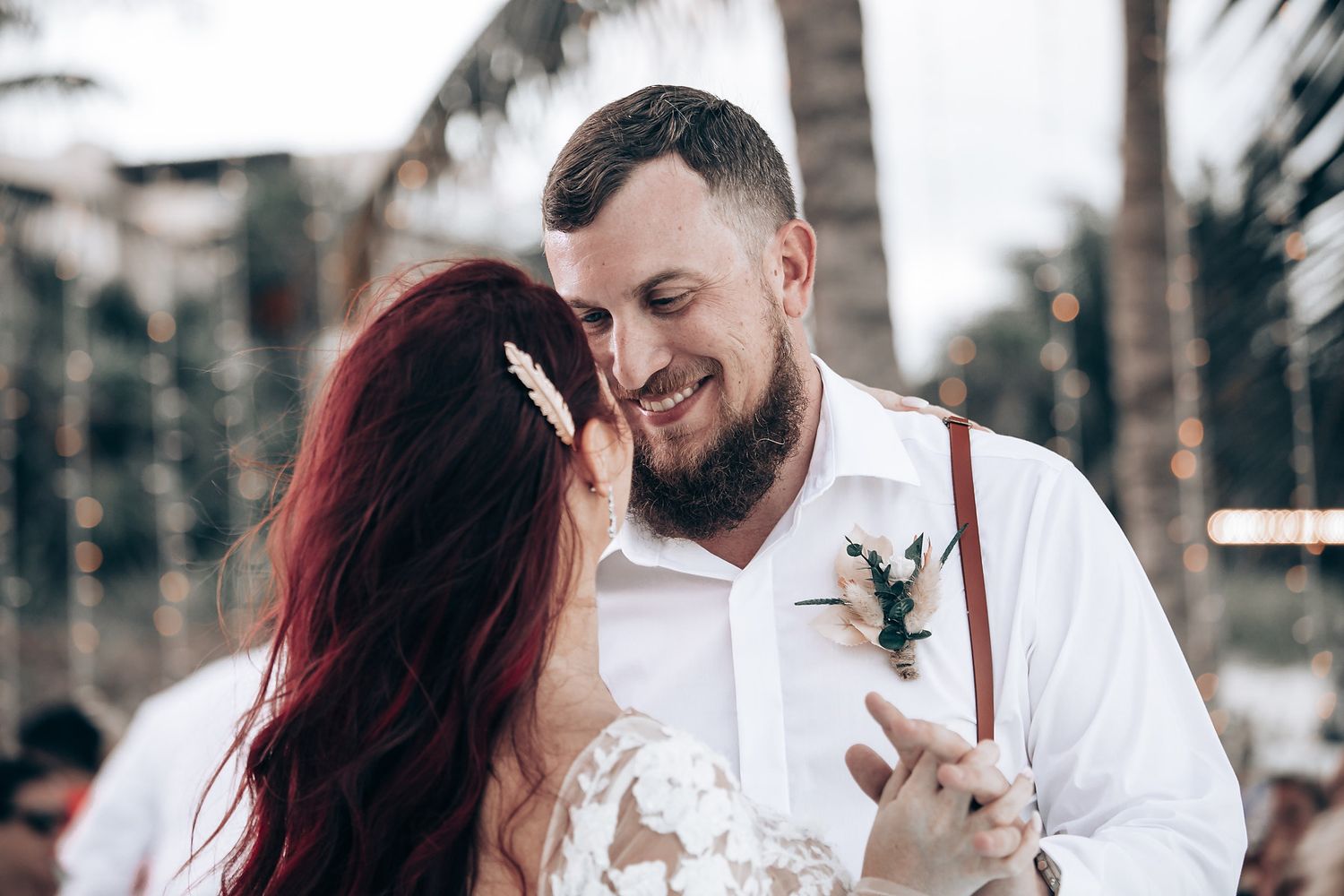 Intimate wedding portrait session under palm trees with soft natural lighting.