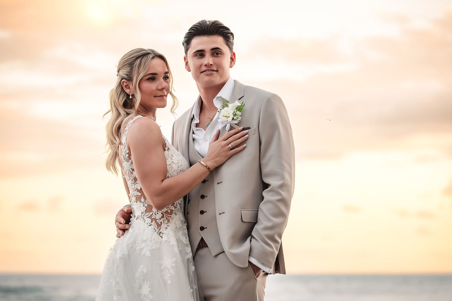 Romantic beach wedding portraits during golden hour with palm trees in background.