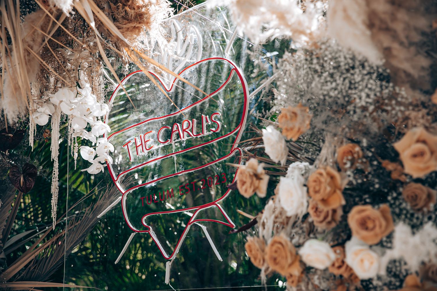 Elegant floral wedding decor with peach roses and white flowers arranged in rustic style against dark background.