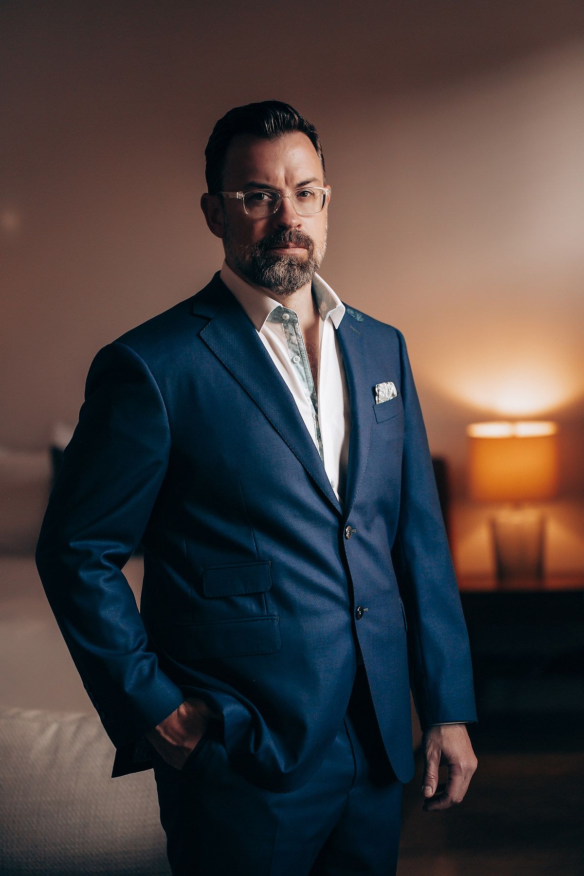 Professional portrait series in navy suit against moody sunset backdrop with dramatic lighting and elegant poses.