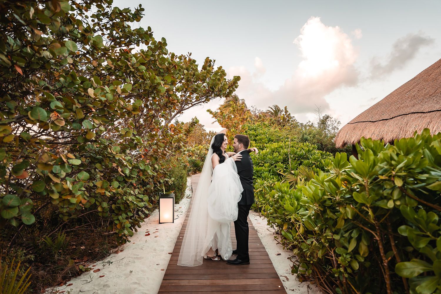 Couple walking down a lush tropical garden pathway.