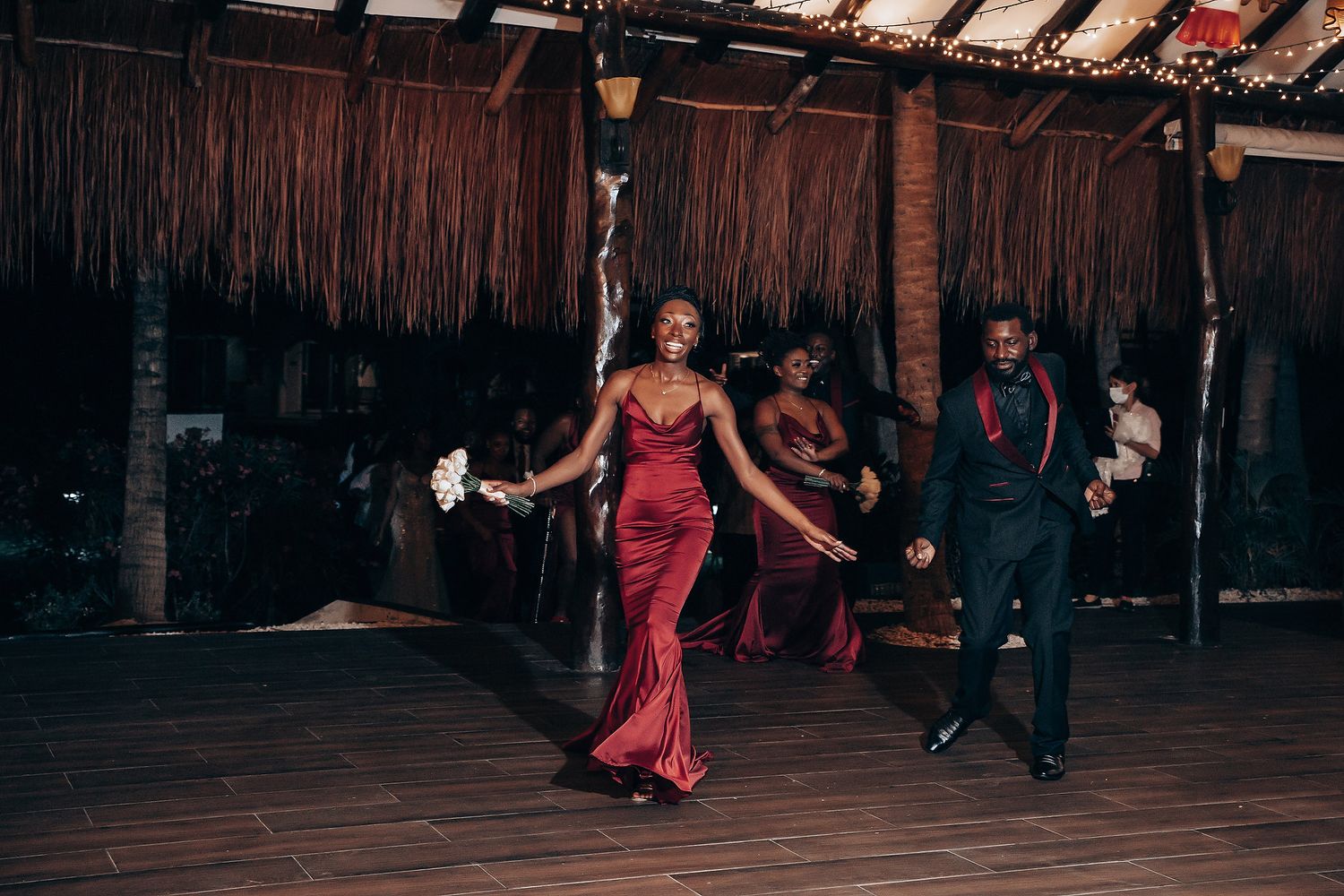 Wedding reception dance sequence showing guests in formal attire moving across wooden dance floor.