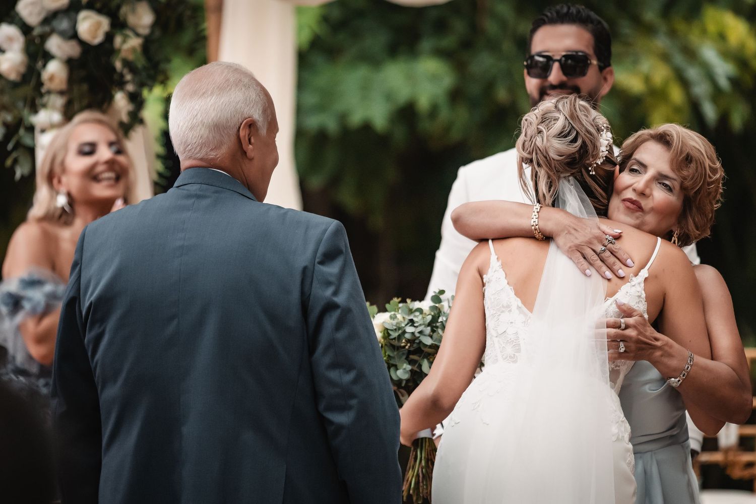Emotional moments captured during an outdoor wedding reception under natural lighting.