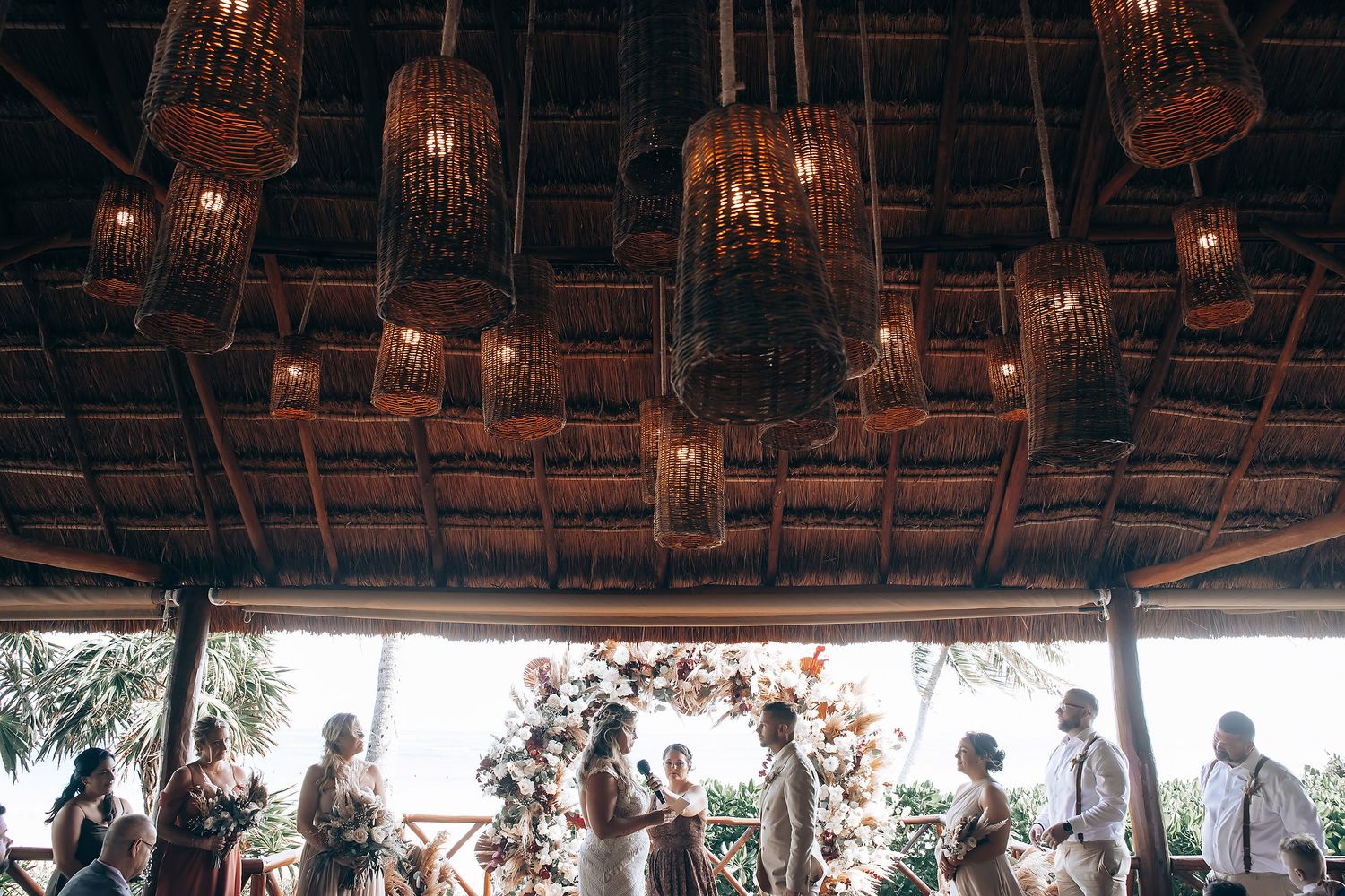 Warm lighting illuminates a rustic wooden ceiling during an evening celebration.