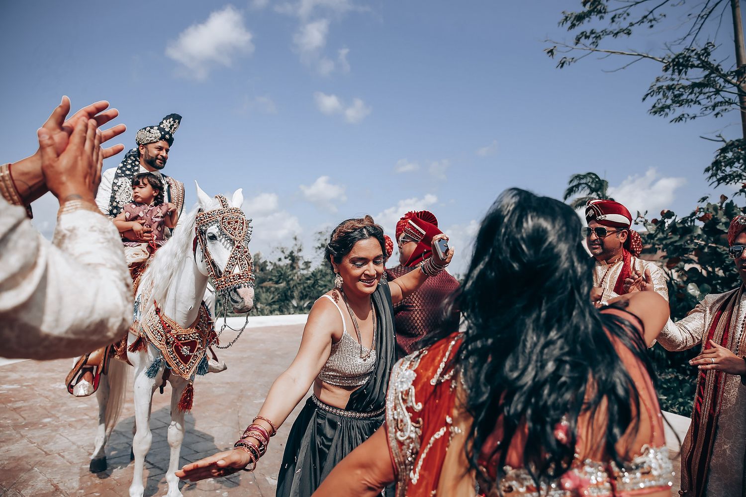 Wedding party dancing and celebrating outdoors with joyful movements in a candid moment.