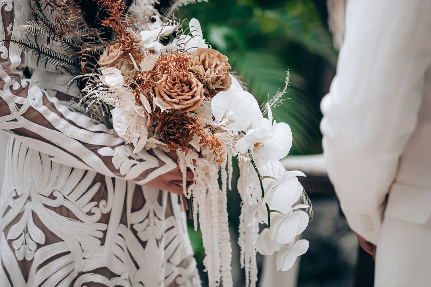 Elegant wedding decorations featuring white and blush pink floral arrangements with delicate lace-like patterns.