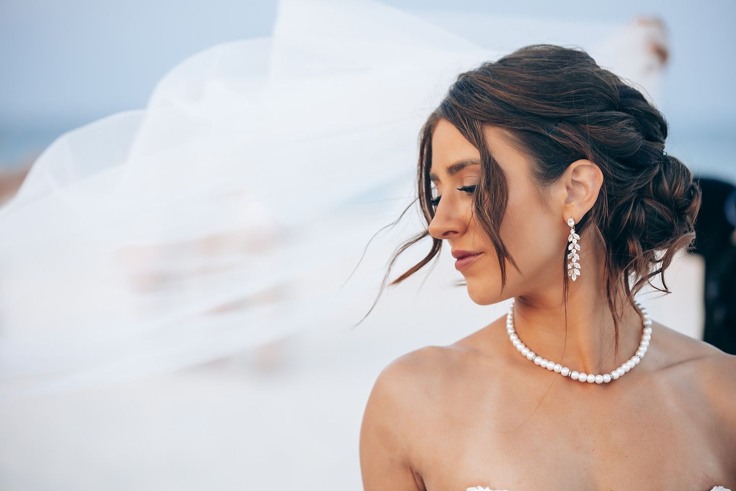 Close-up details of bridal jewelry and accessories against a soft blue background.