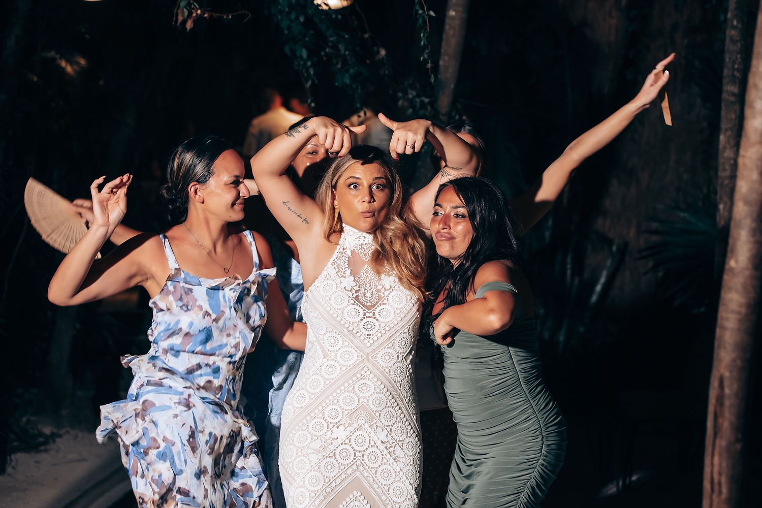 Wedding party dancing and celebrating at night on tropical beach.