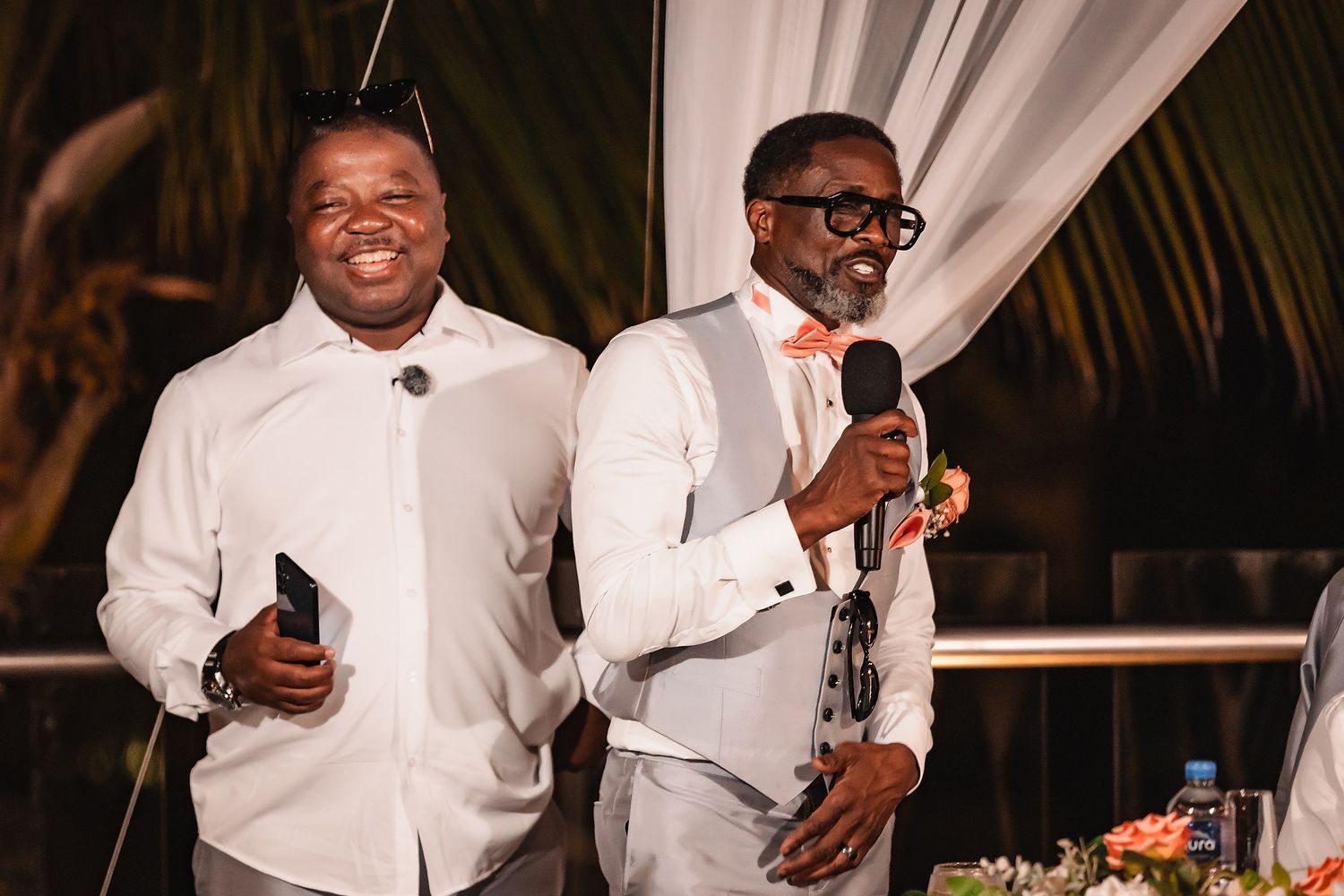 Wedding reception celebration with guests in white attire enjoying festivities.