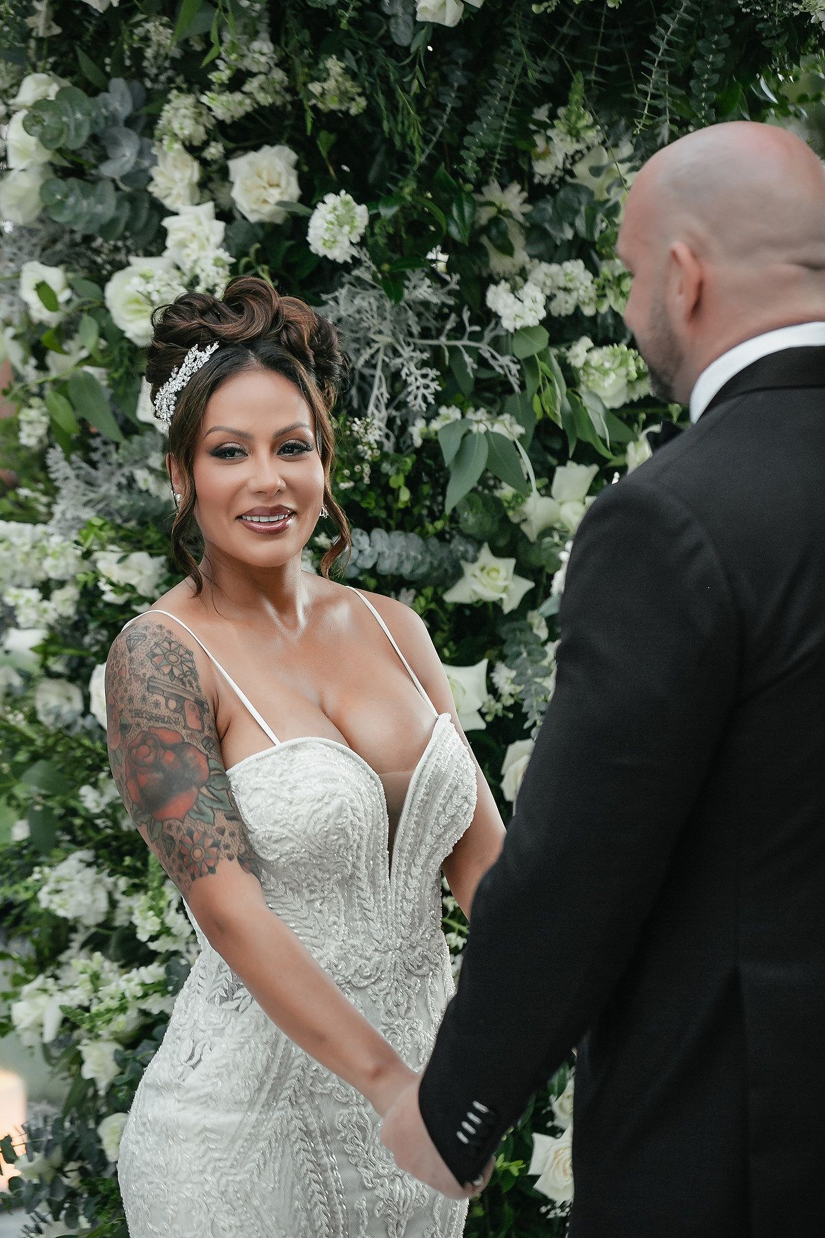 A series of candid moments at a wedding ceremony with floral decor and white blooms in the background.