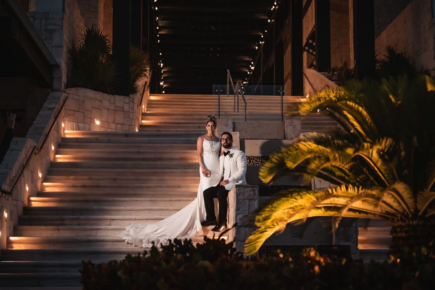 Wedding photography at night with palm trees and outdoor lighting creating a romantic ambiance.