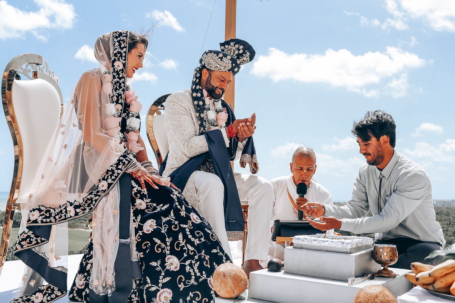 Group gathered around traditional ceremony items during outdoor rooftop wedding.