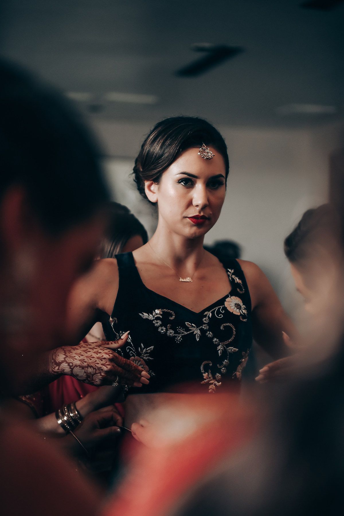 Dramatic indoor portrait with moody lighting and formal black dress.
