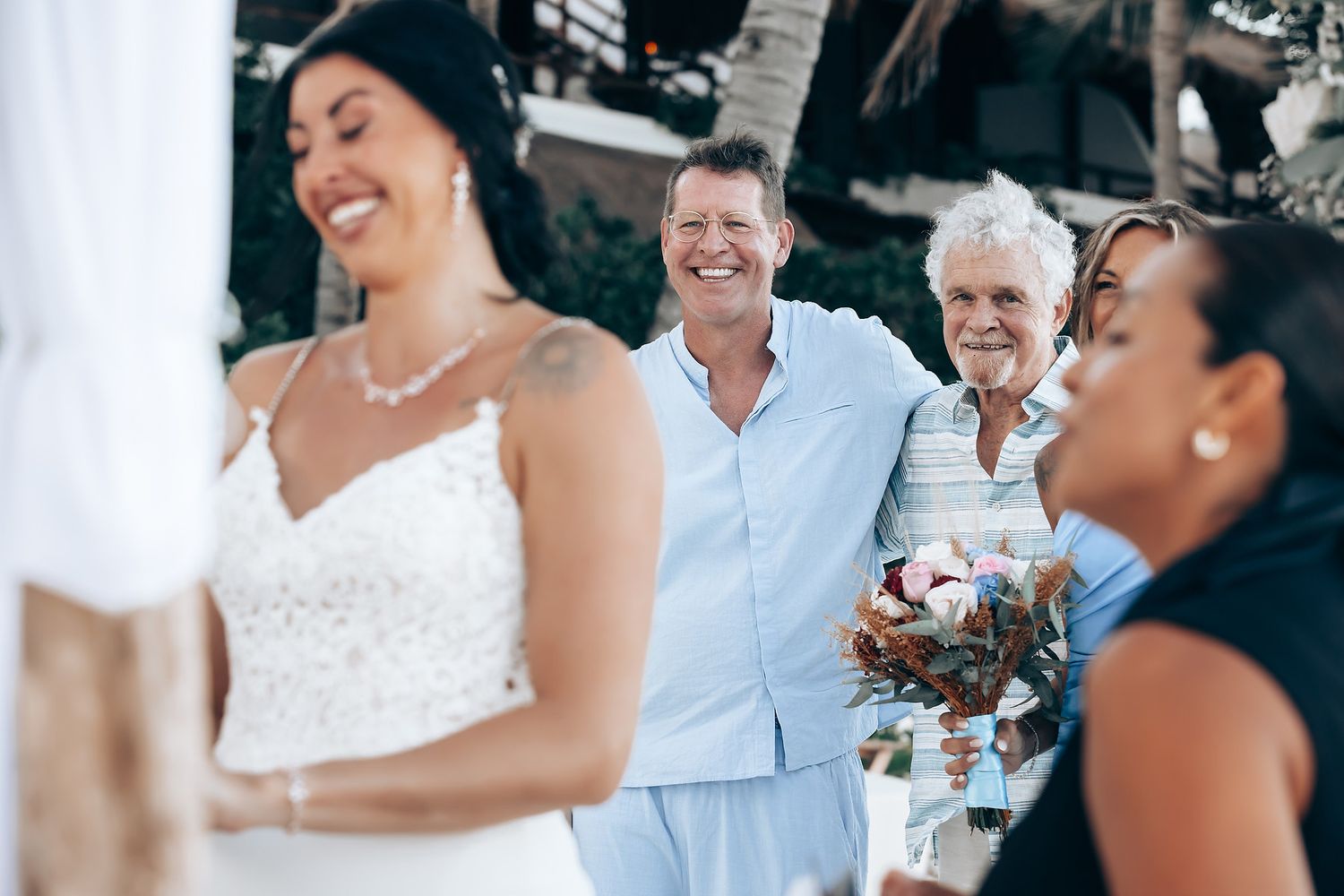A wedding ceremony on a beach with a couple and their guests.