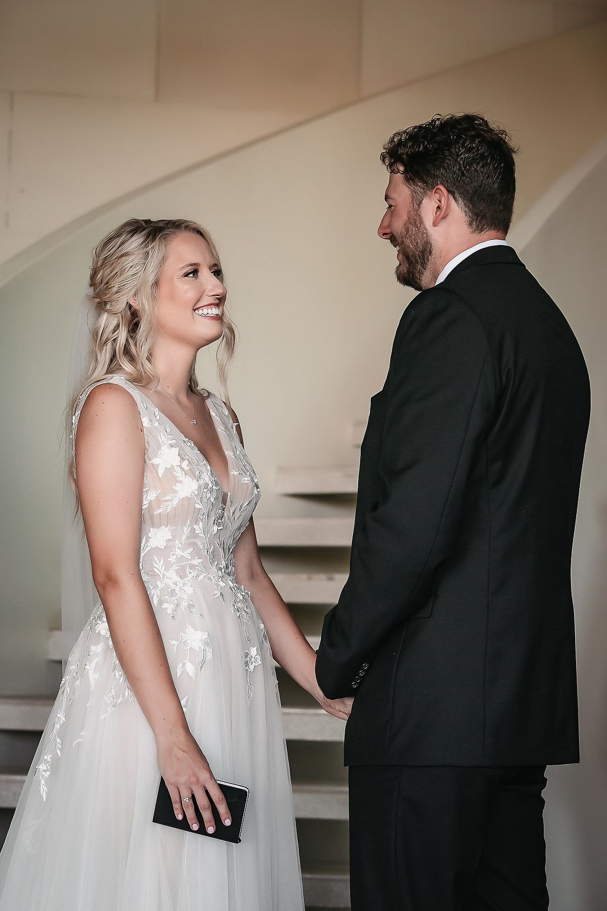 Candid sequence of bride and groom sharing first look moments in indoor venue.