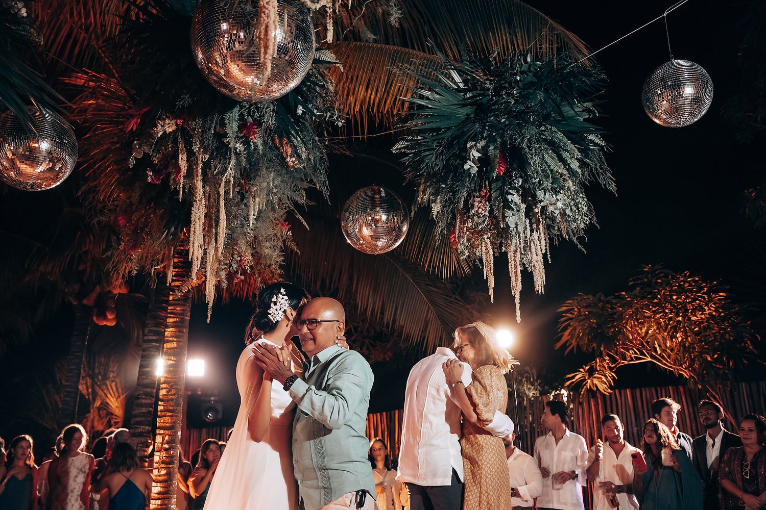 Disco ball sparkles above wedding reception dance floor.