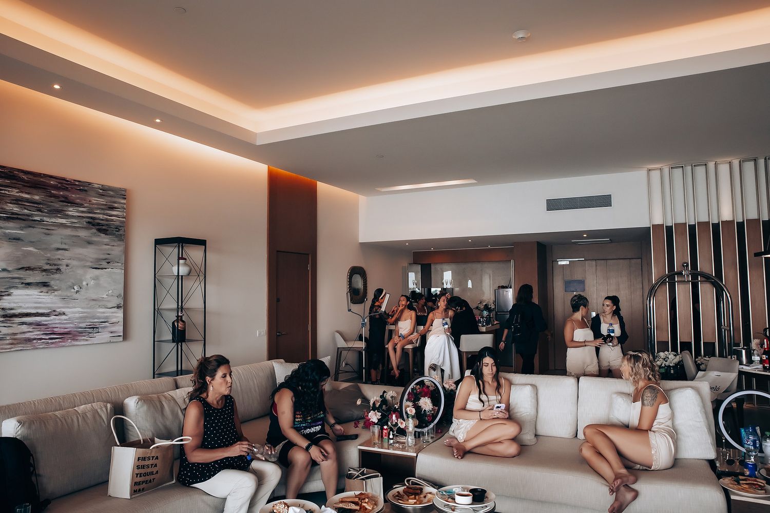 Guests gathered in a modern hotel suite with ambient lighting and contemporary decor.