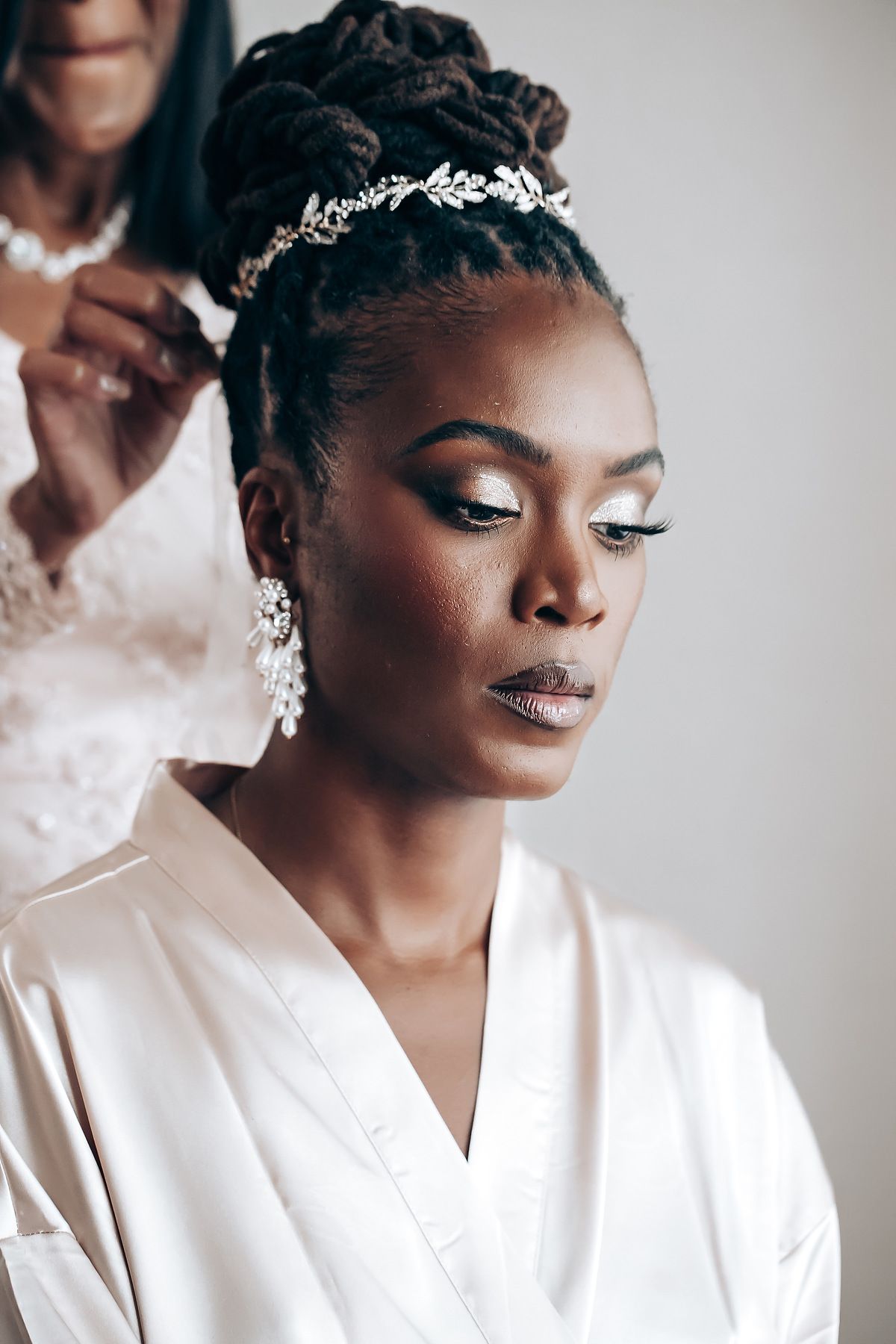 A close-up beauty shot showing glamorous bridal makeup and a delicate hair accessory.