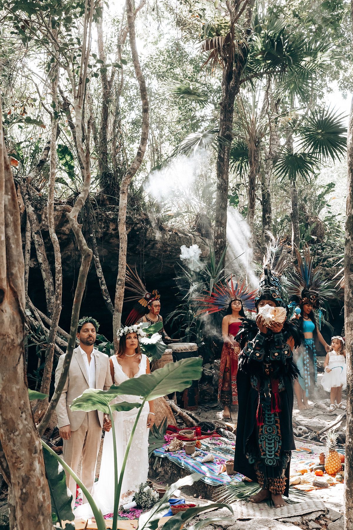 A panoramic view of a forest wedding ceremony with traditional Mayan elements and decorative blankets.