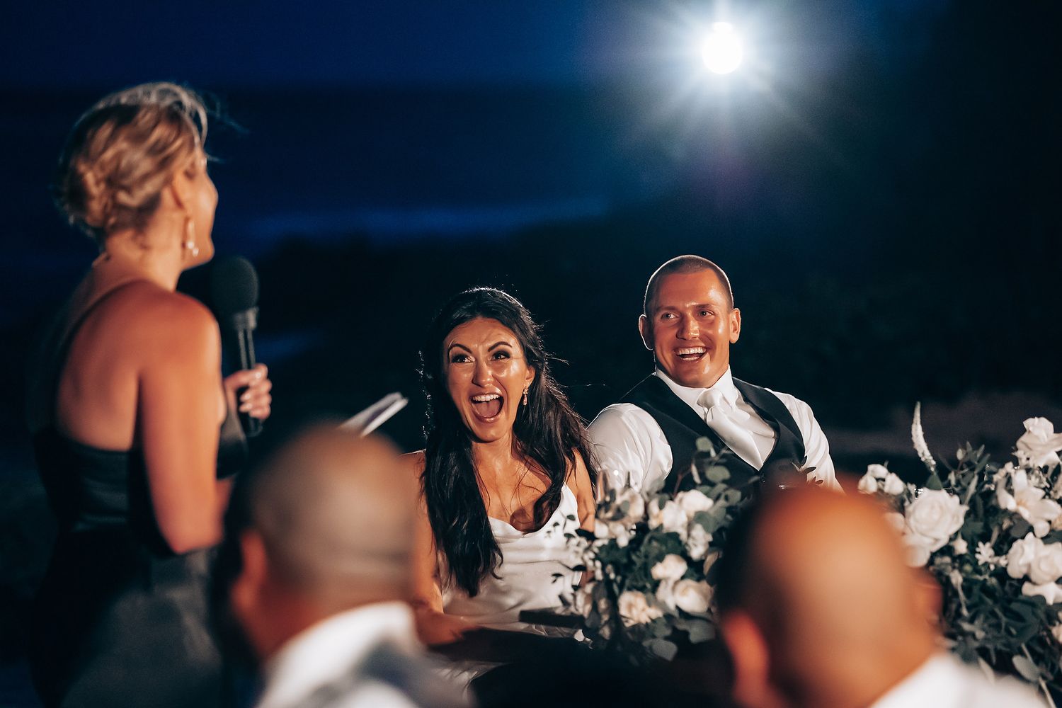 Evening wedding reception with dramatic lighting and celebratory atmosphere.