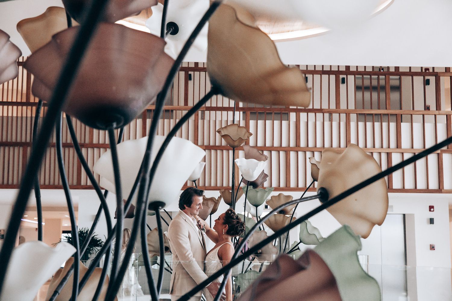 Wedding reception venue with elegant wooden chairs and table settings.