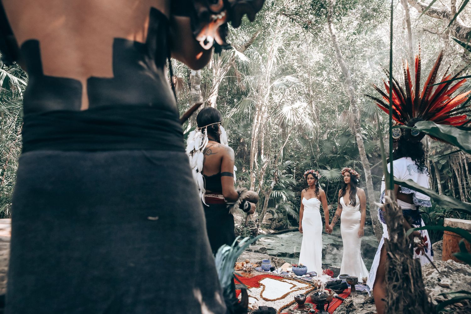 Outdoor wedding ceremony setup in a lush forest setting with natural decor and filtered sunlight.