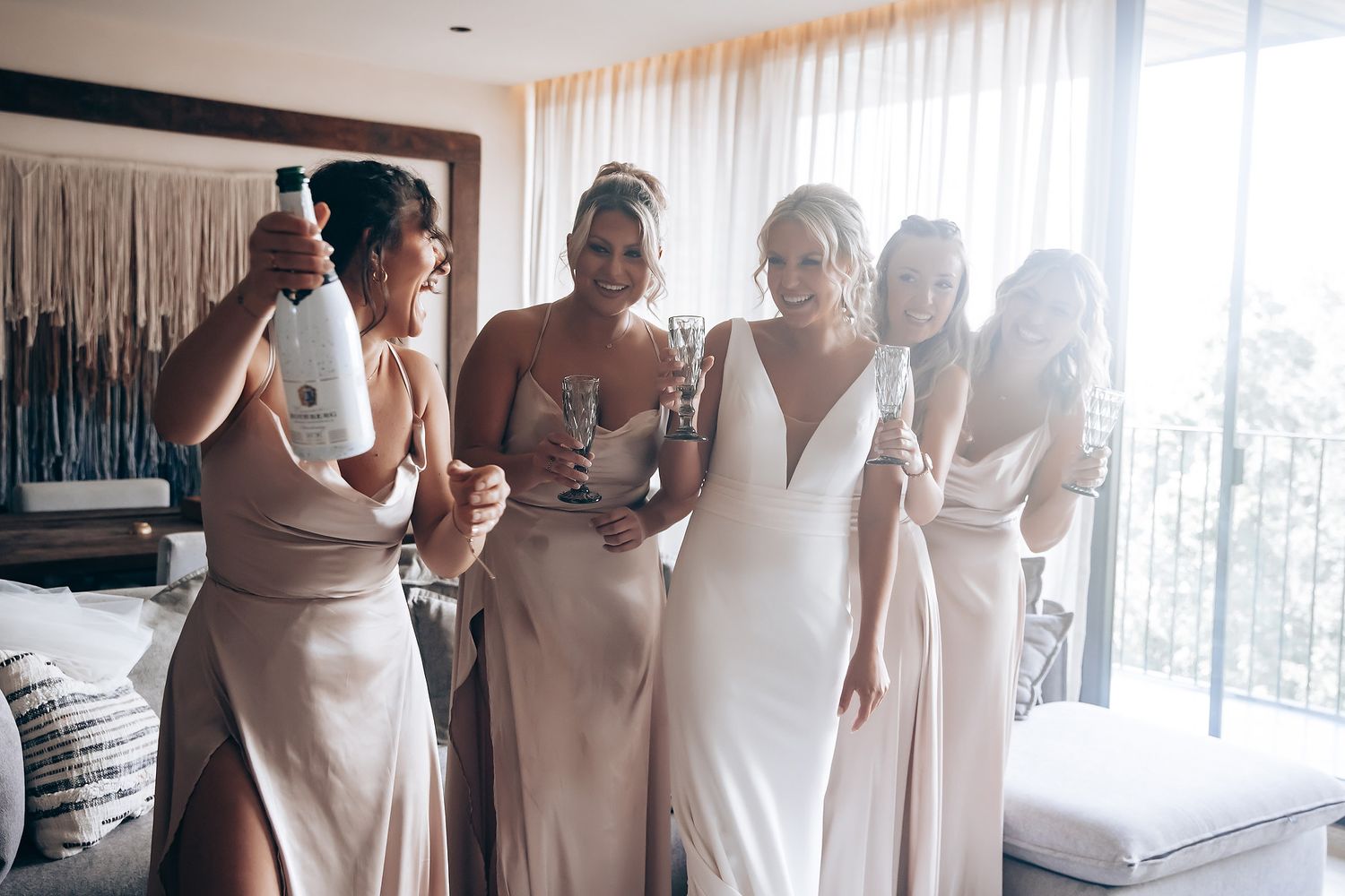 A group of friends in elegant dresses share a special moment while getting ready for a celebration.