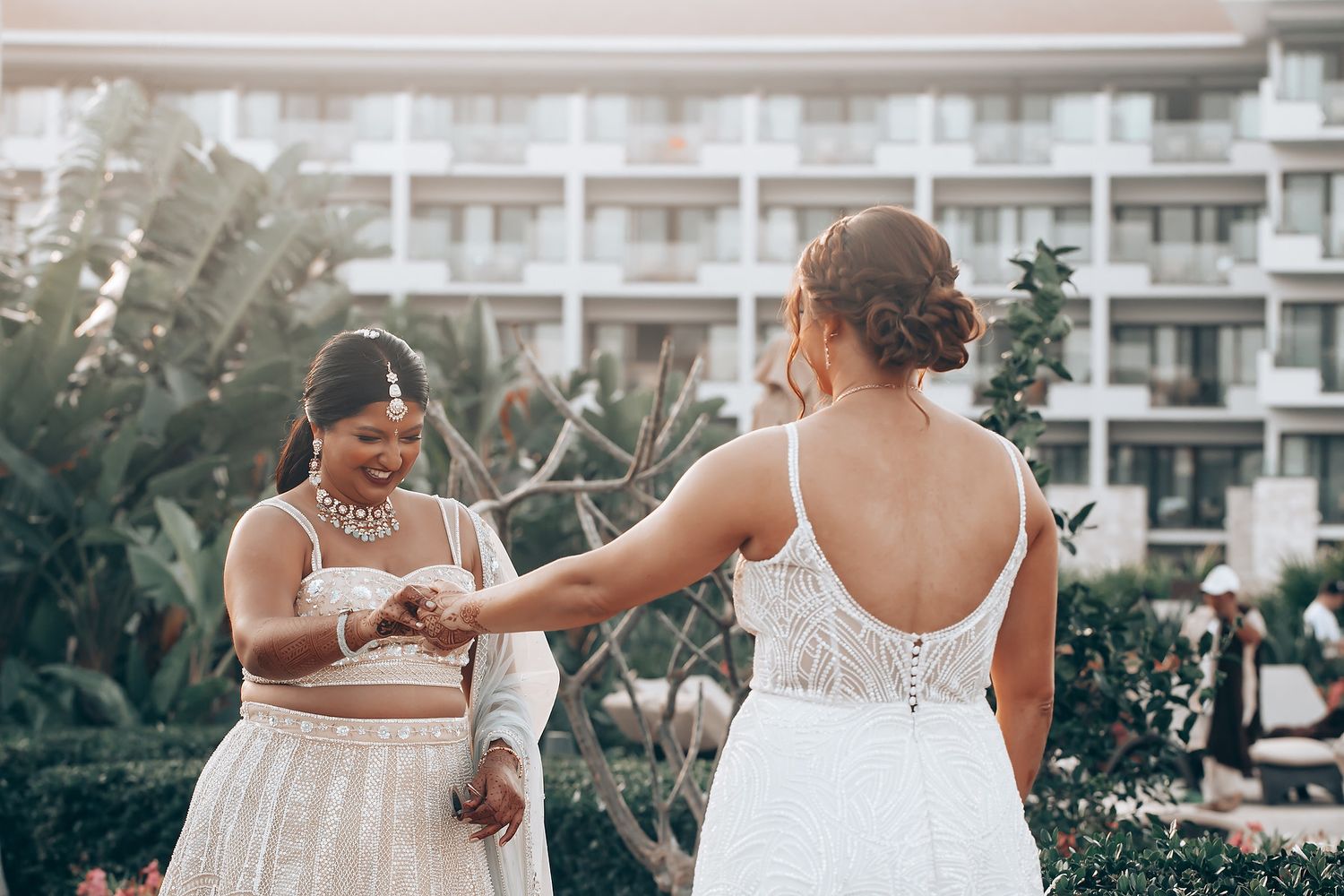 Wedding party posing in front of a modern hotel building with white balconies.