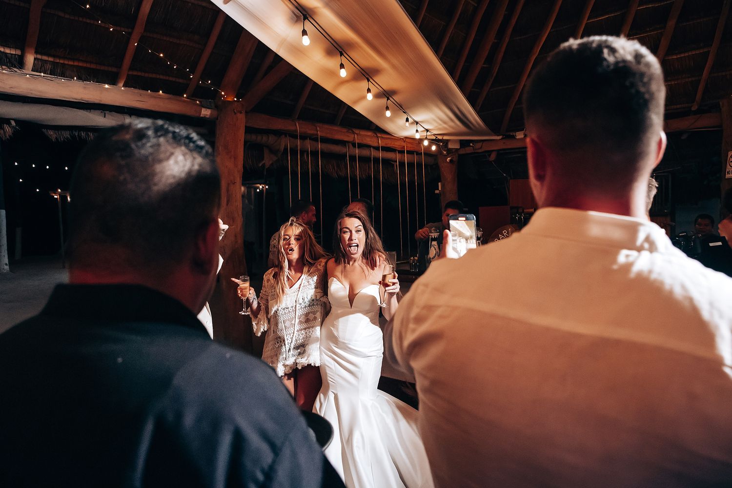 A series of candid dance floor moments at a wedding reception with guests enjoying themselves under warm lighting.