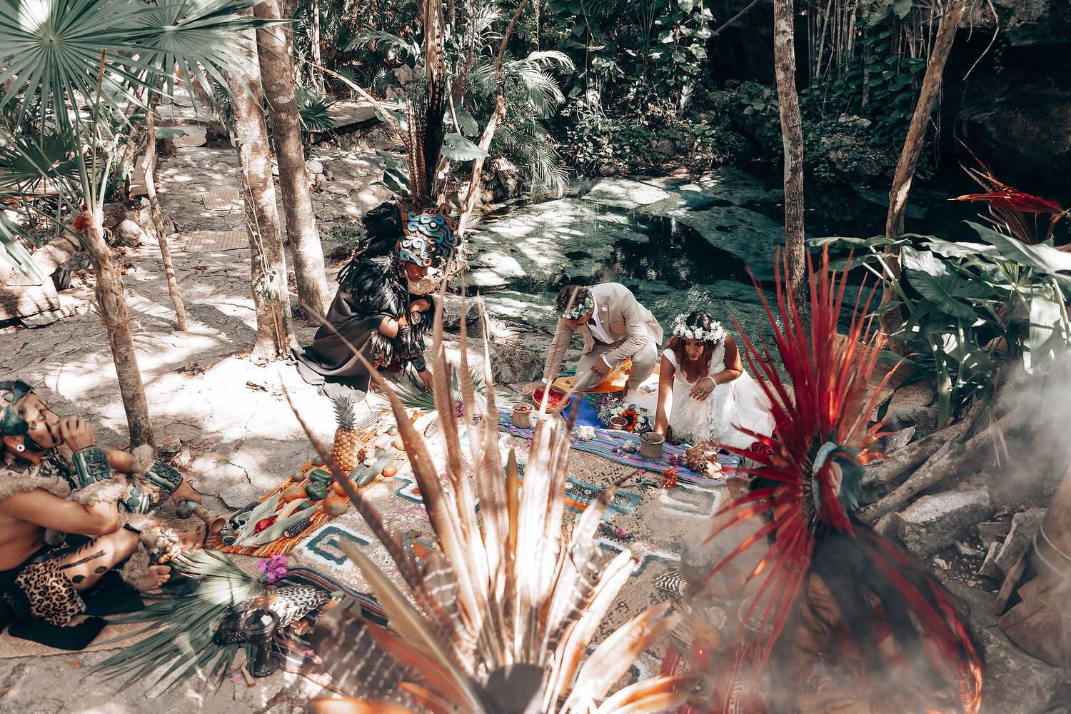 Sacred ceremony in jungle clearing with red feathered ceremonial headdress.