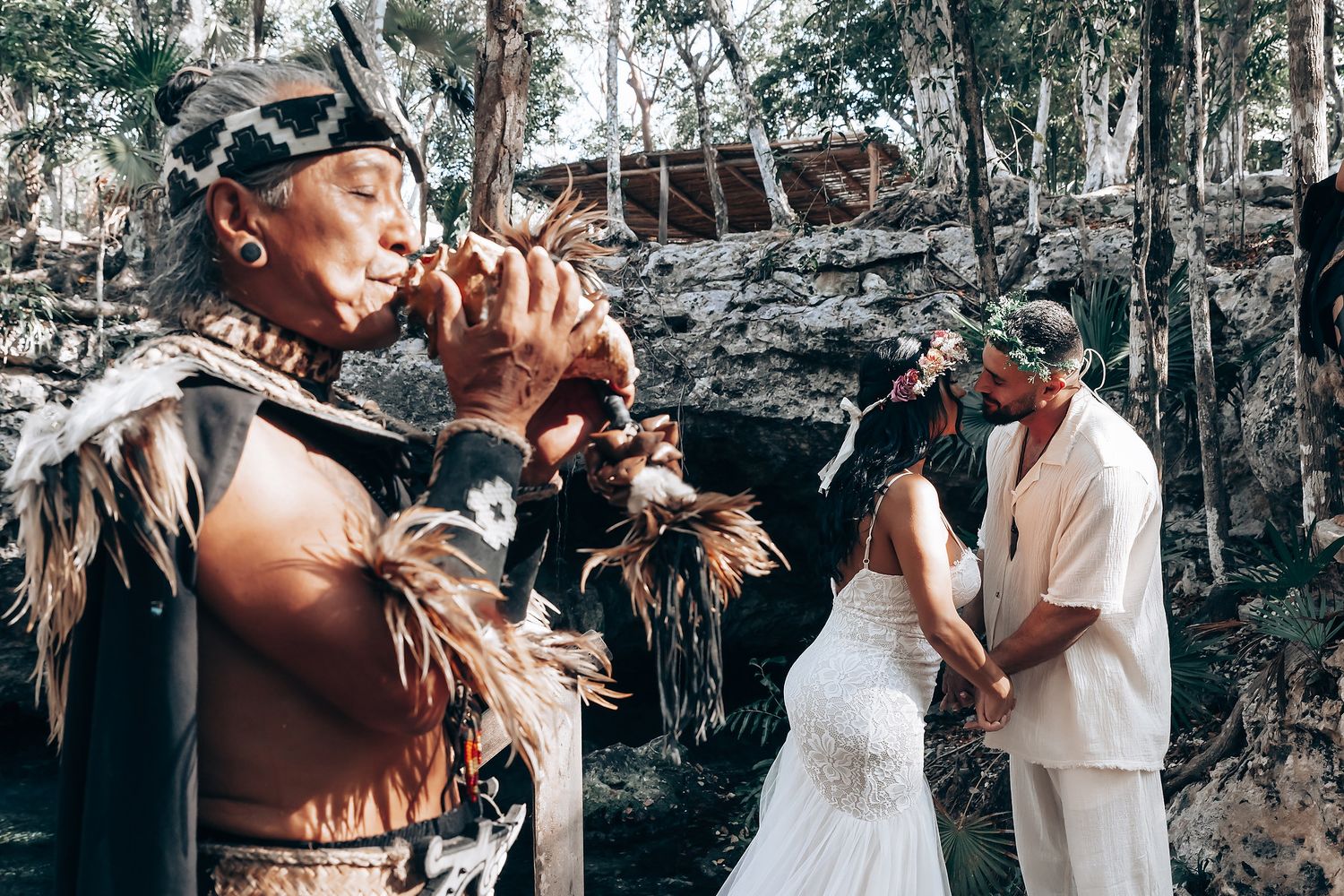 A couple shares a romantic dance together during an outdoor wedding celebration in a wooded setting.