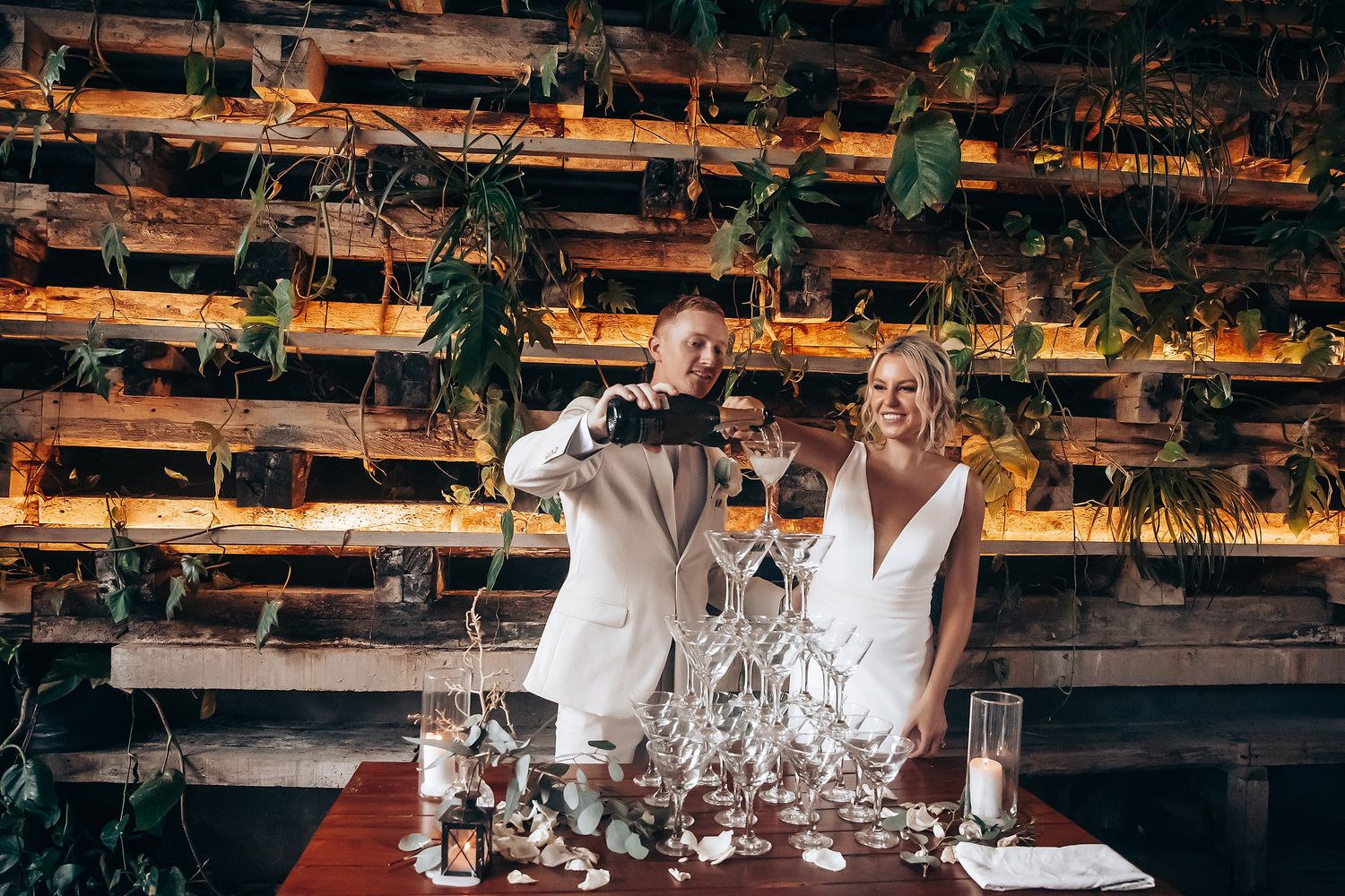 Wedding reception venue decorated with rustic wooden beams and hanging greenery creates a warm atmosphere.