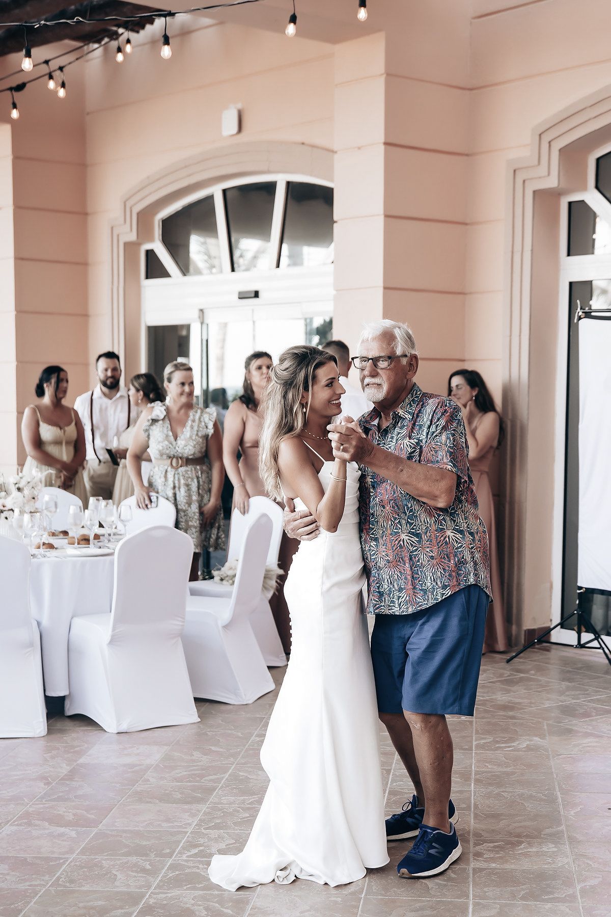 A group of people, including a bride and groom, gather at a wedding reception.