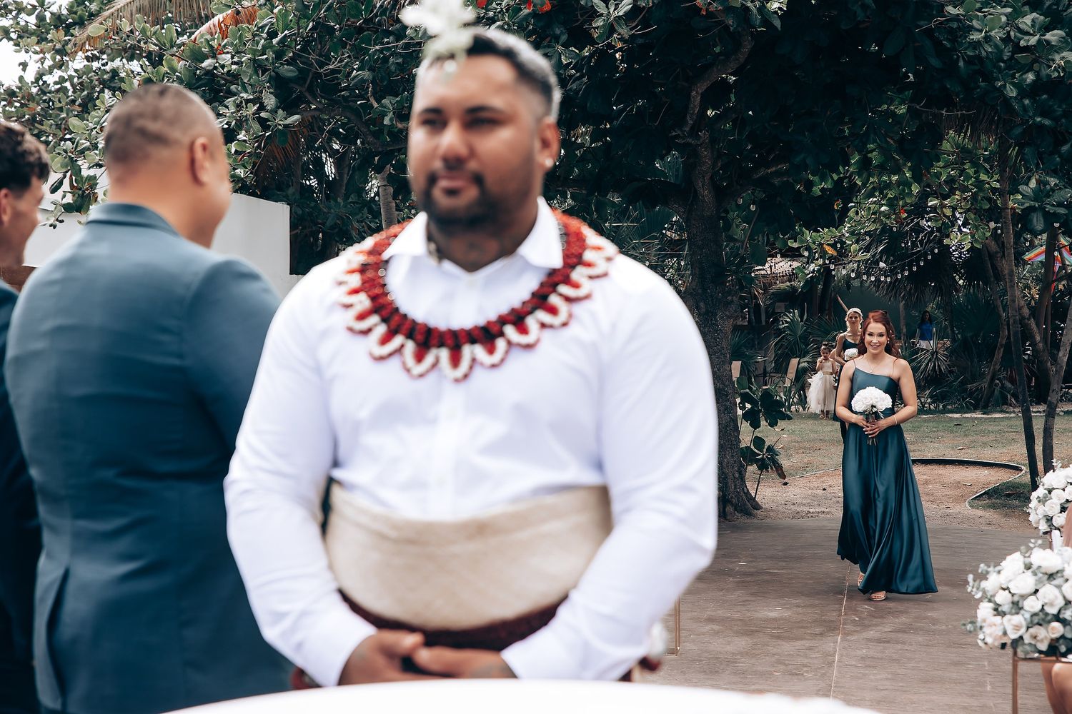 Wedding guests gathered at an outdoor ceremony venue with traditional decorations.