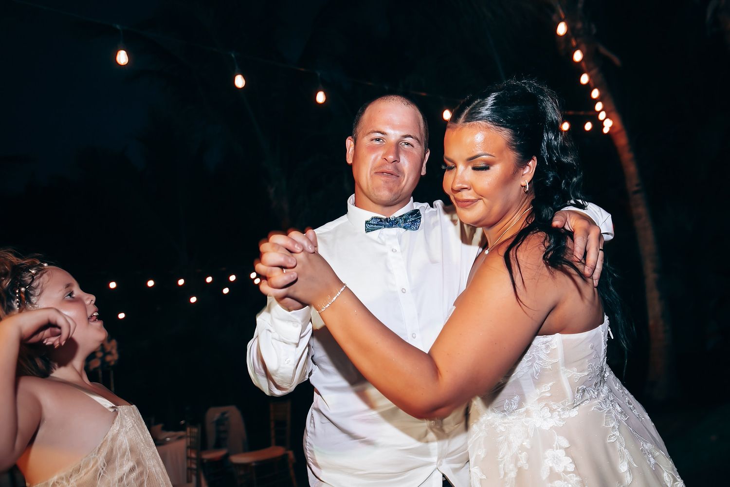 Couples dancing and celebrating at an evening wedding reception.