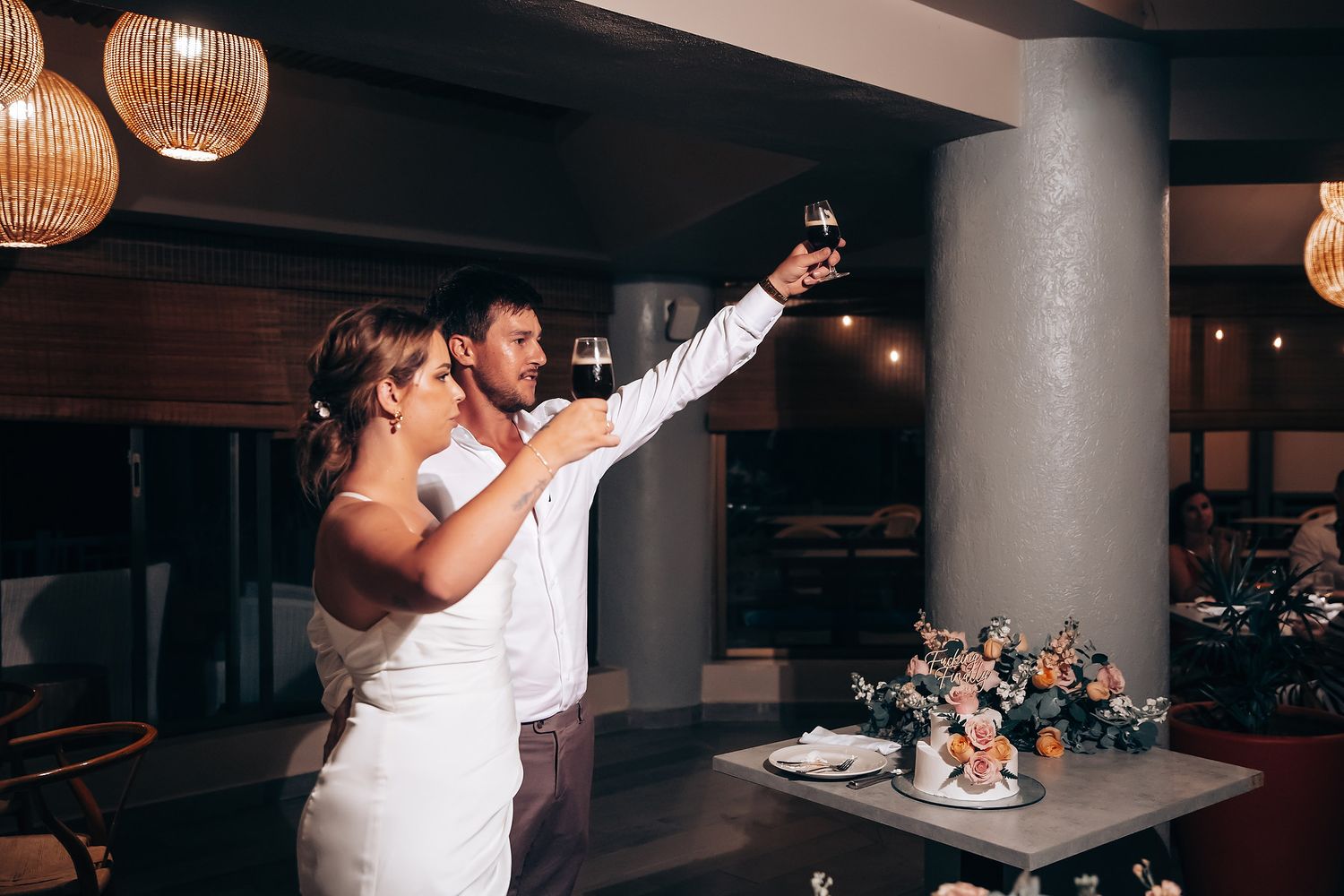 Wedding reception venue with hanging wicker lanterns and modern column interior.